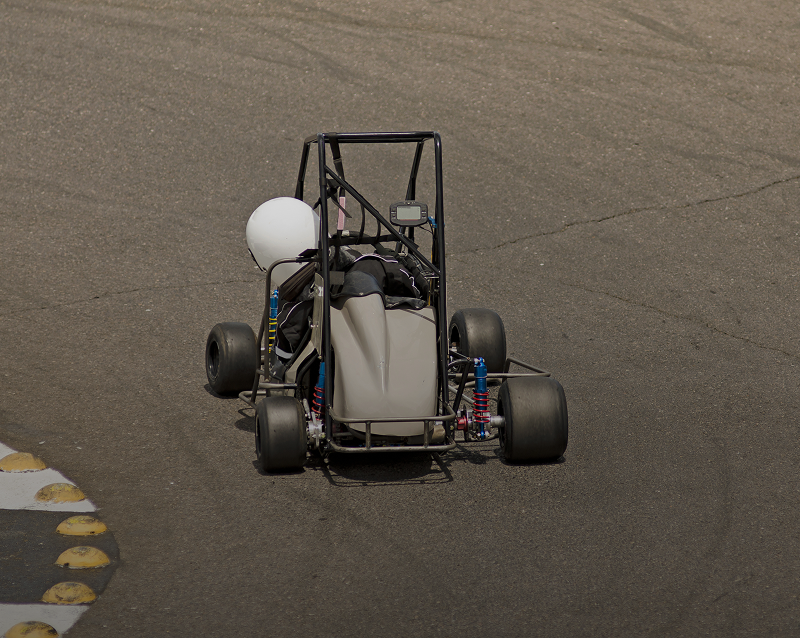 Go-kart racing on asphalt track, aerial view.