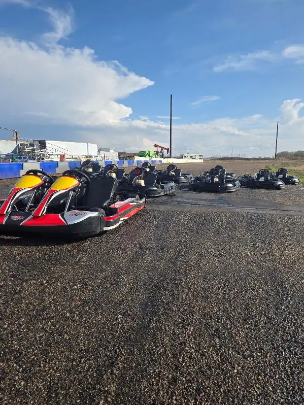 kart pic 1 A group of people riding on the back of a go kart.